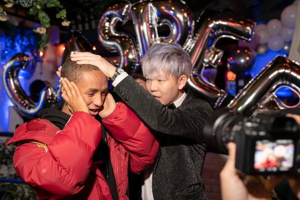 Guests at a celebrity party grabbing their heads in disbelief