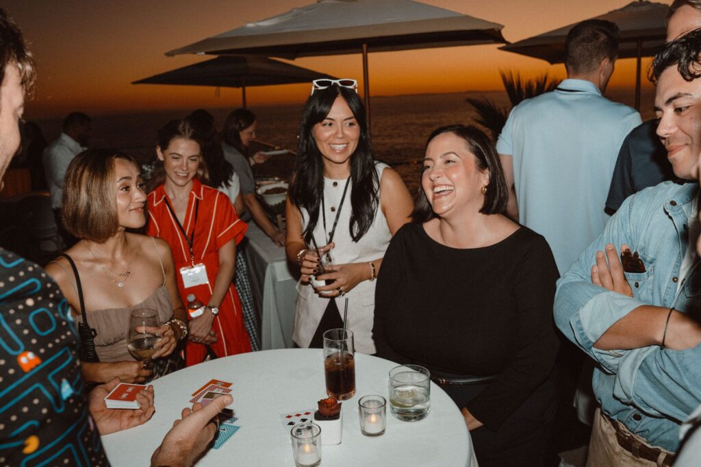 Conference guests laughing at a sunset rooftop reception with strolling magic by Omni Magic magician Dylan