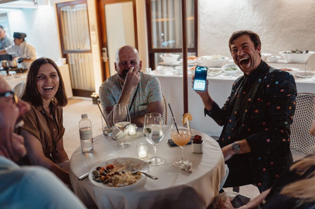 Omni Magic magician Dylan and a table of guests burst out laughing at a phone magic reveal
