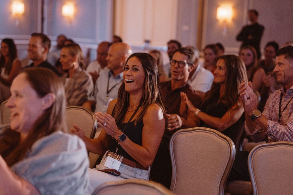 Corporate audience laughing and clapping during the Johnny Wu mentalism show