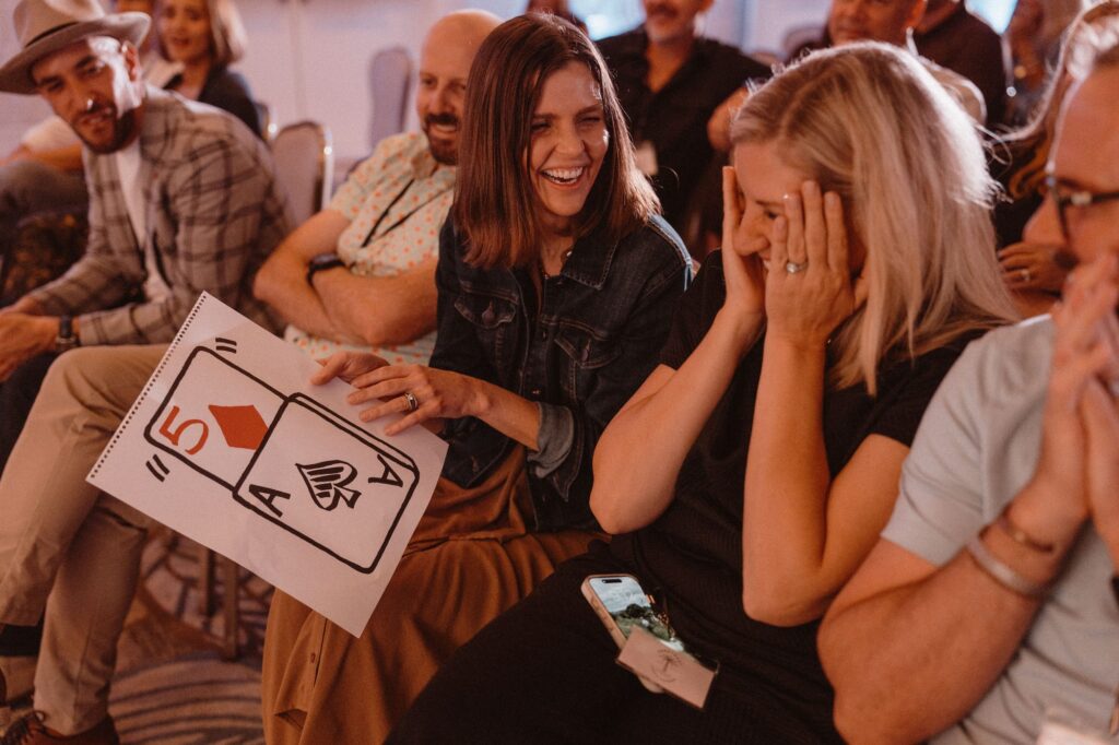 A guest covers her face in shock as her chosen card is revealed by Johnny Wu