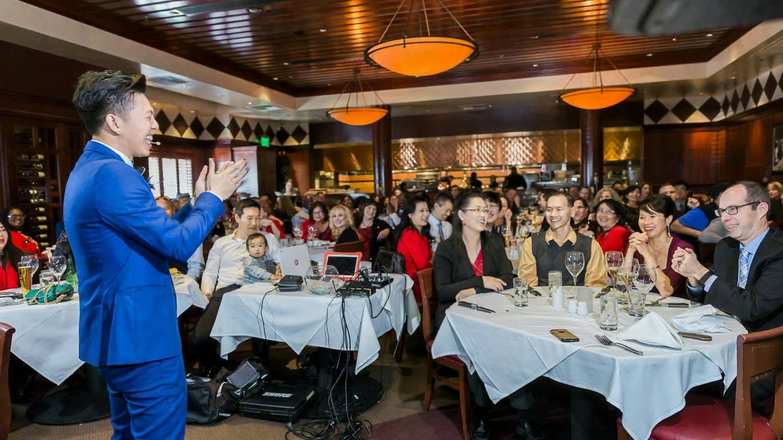 Johnny Wu performing for a full room at a company dinner