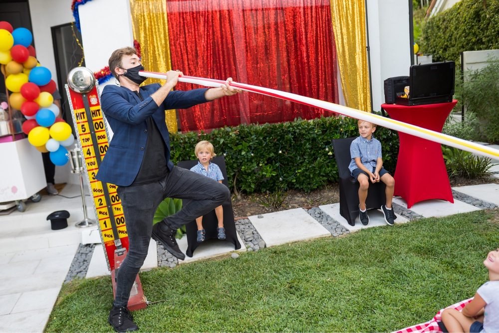 Dylan George performing at a kids party with balloons and streamers