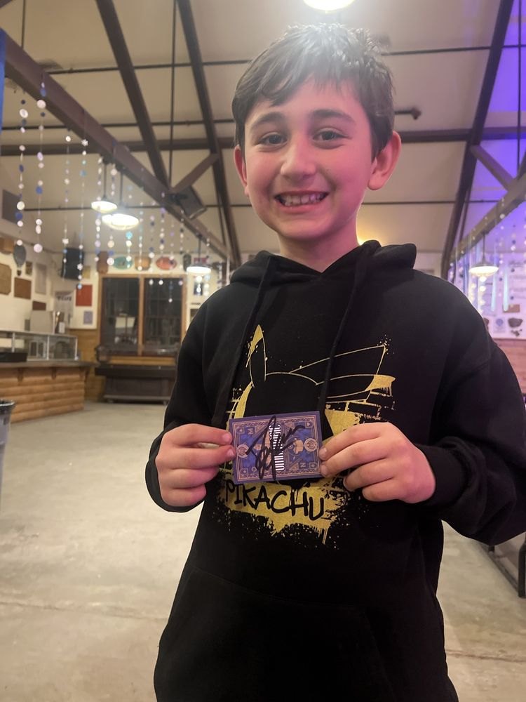A young guest showing off the card Dylan George signed for him
