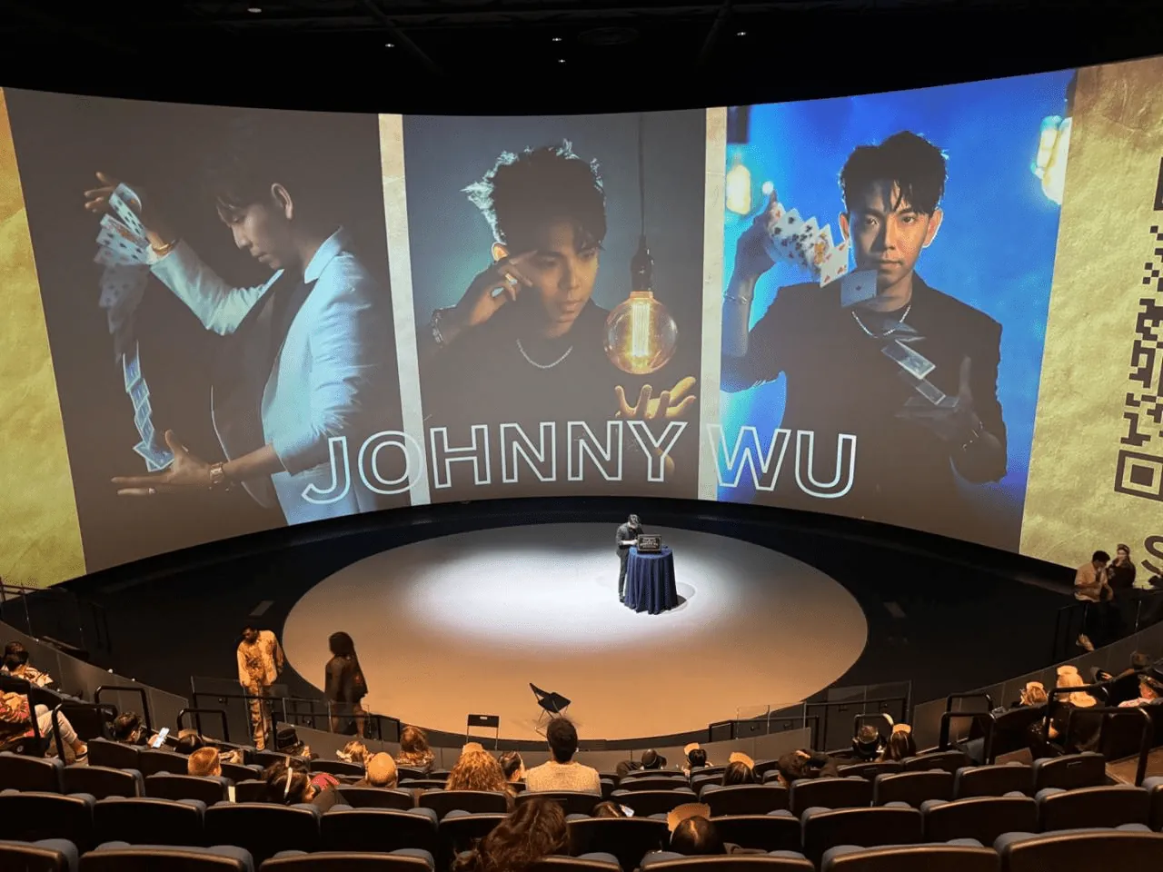 Johnny Wu performing on a large theater stage with video screens