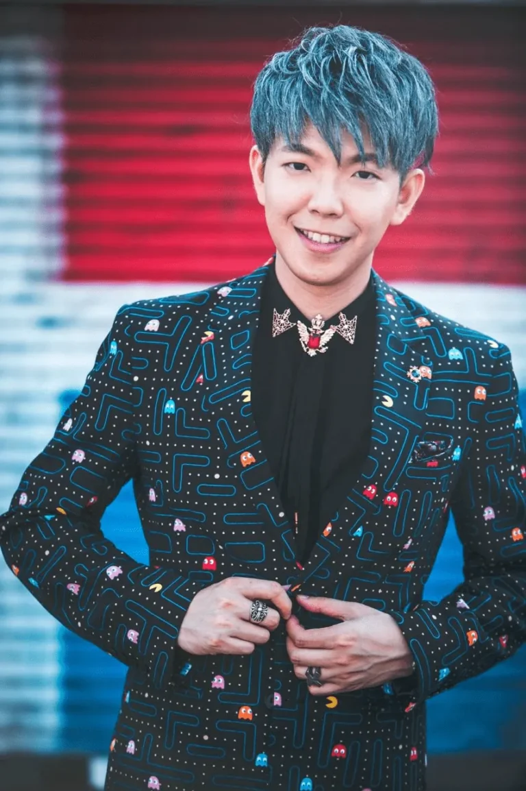 Corporate magician Johnny Wu on stage in a patterned suit