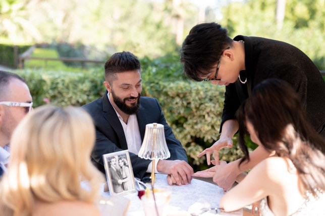 Johnny Wu performing magic for guests at a wedding
