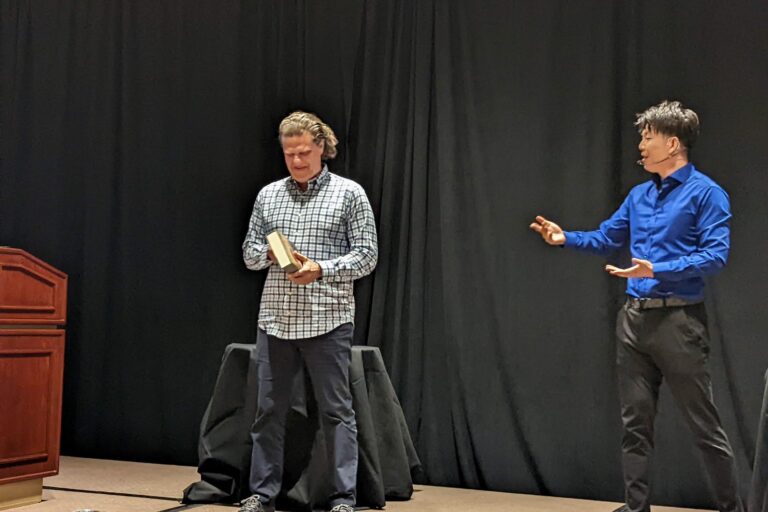 Johnny Wu reading a volunteer's mind on stage at a corporate event
