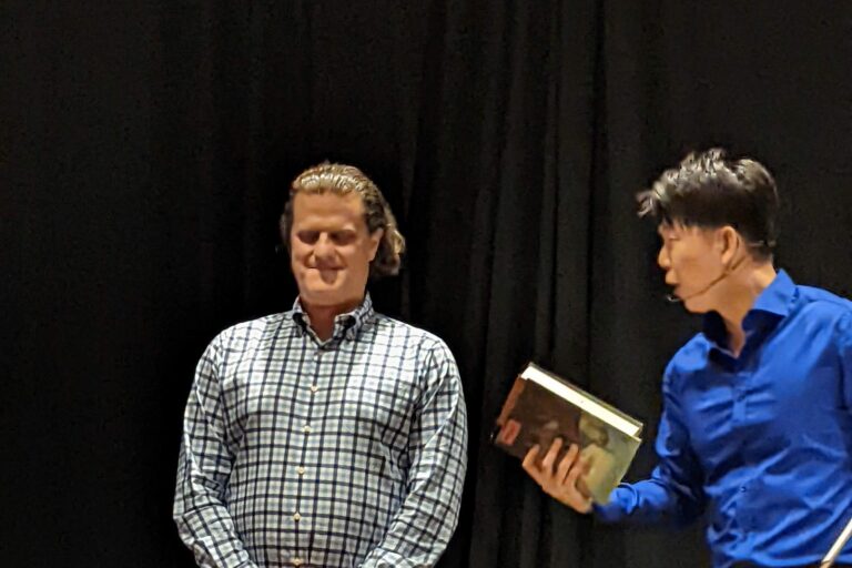 Johnny Wu reading a volunteer's mind on stage at a corporate event