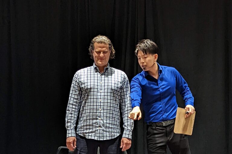 Johnny Wu reading a volunteer's mind on stage at a corporate event