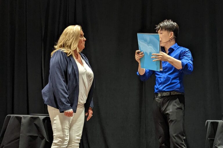 Johnny Wu reading a volunteer's mind on stage at a corporate event
