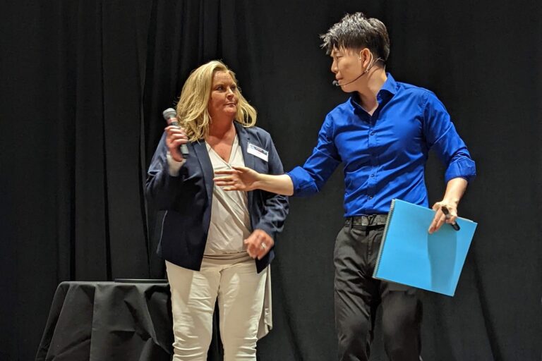 Johnny Wu reading a volunteer's mind on stage at a corporate event