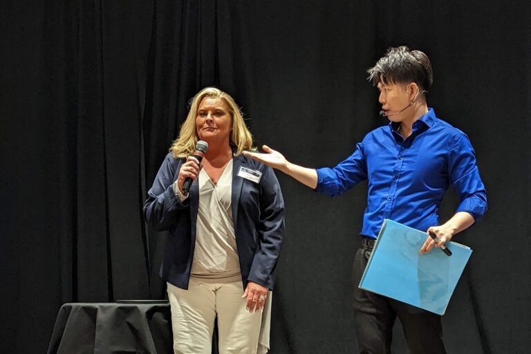 Johnny Wu reading a volunteer's mind on stage at a corporate event