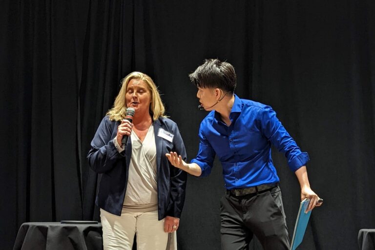 Johnny Wu reading a volunteer's mind on stage at a corporate event