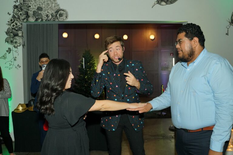 Omni Magic magician Dylan performing strolling magic at a holiday party